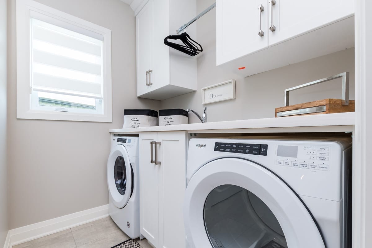 Organized laundry area with a convenient hanging rail above the washer and dryer.