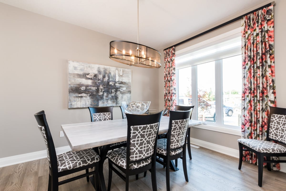 Large dining area styled with bold floral draperies contrasted with a black and white dining set.