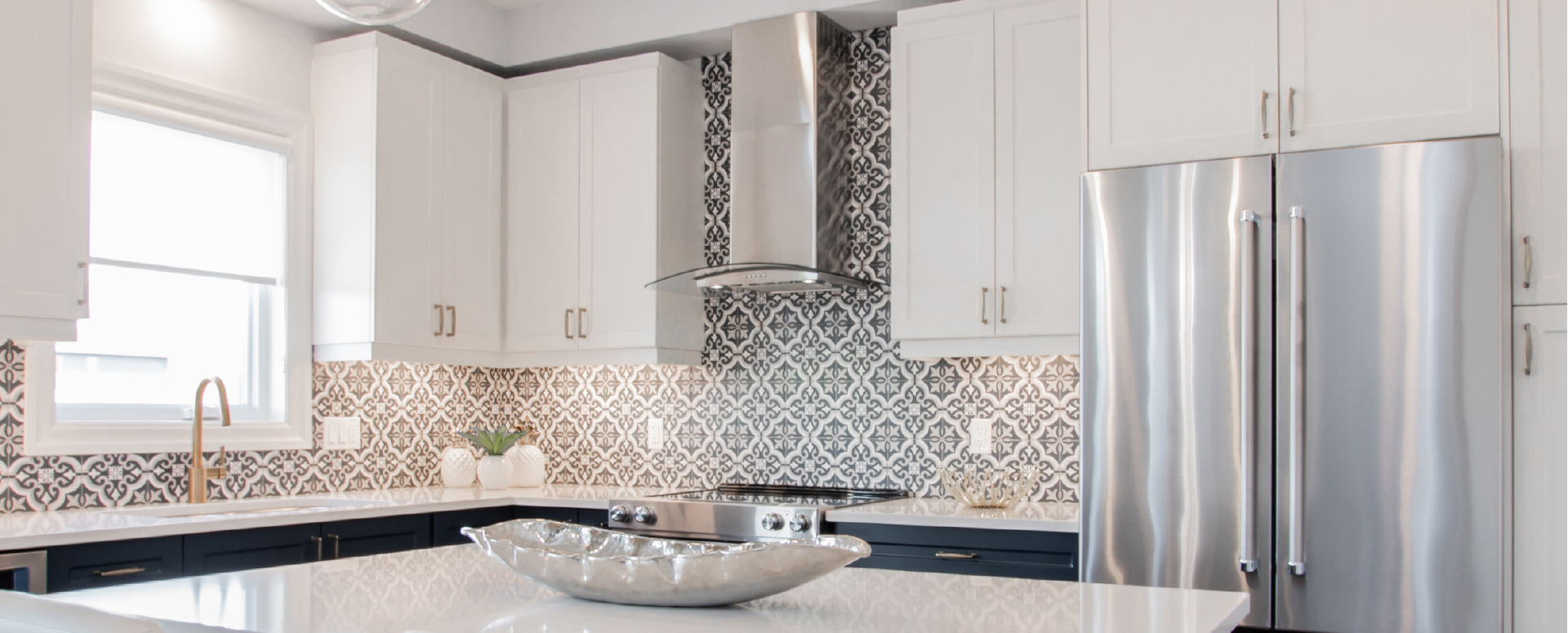 Kitchen at Rembrandt Walk, with patterned backsplash, and contrasting dark blue and white cabinetry