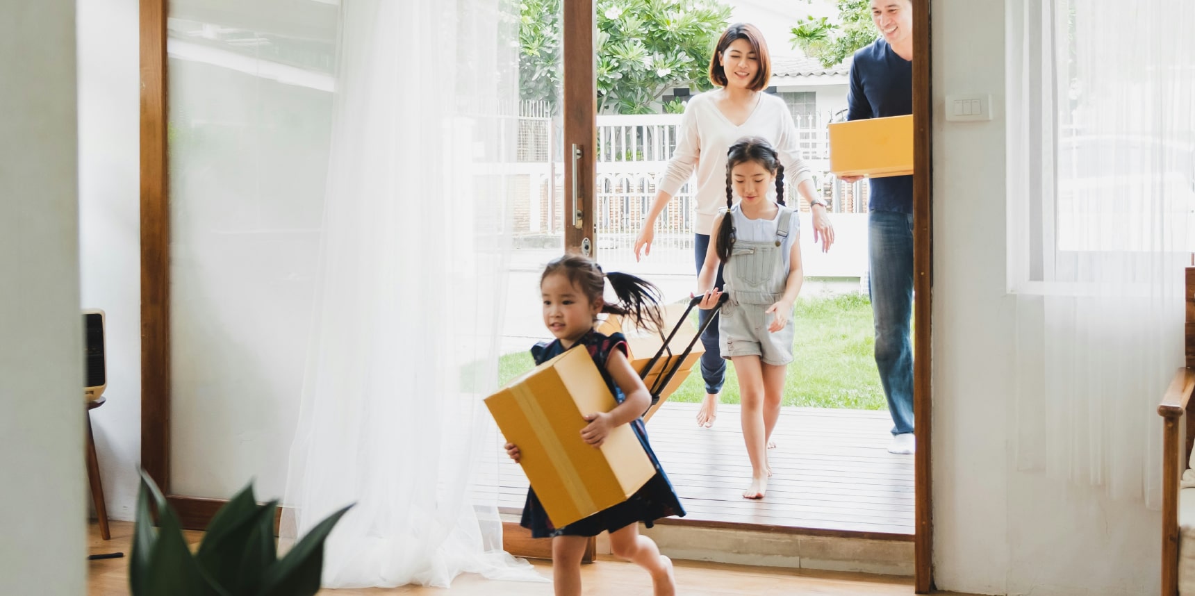 Excited family carrying boxes into their new home.